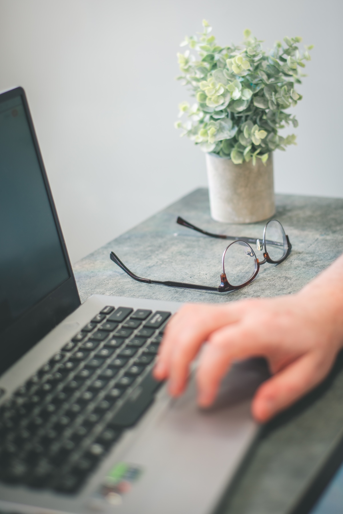 Laptop and glasses on a desk — Adam's workspace